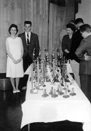 Barbara Frey stands next to John O'Neal as he receives his 100th trophy for dating the best looking girls in 1961...